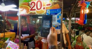 Tangkapan layar Youtube @Bankerindo, Indra memindai QR Code dengan QRIS BCA Mobile saat membeli orange juice di Lee Gardens Night Market, Hat Hai, Thailand Selatan. 
